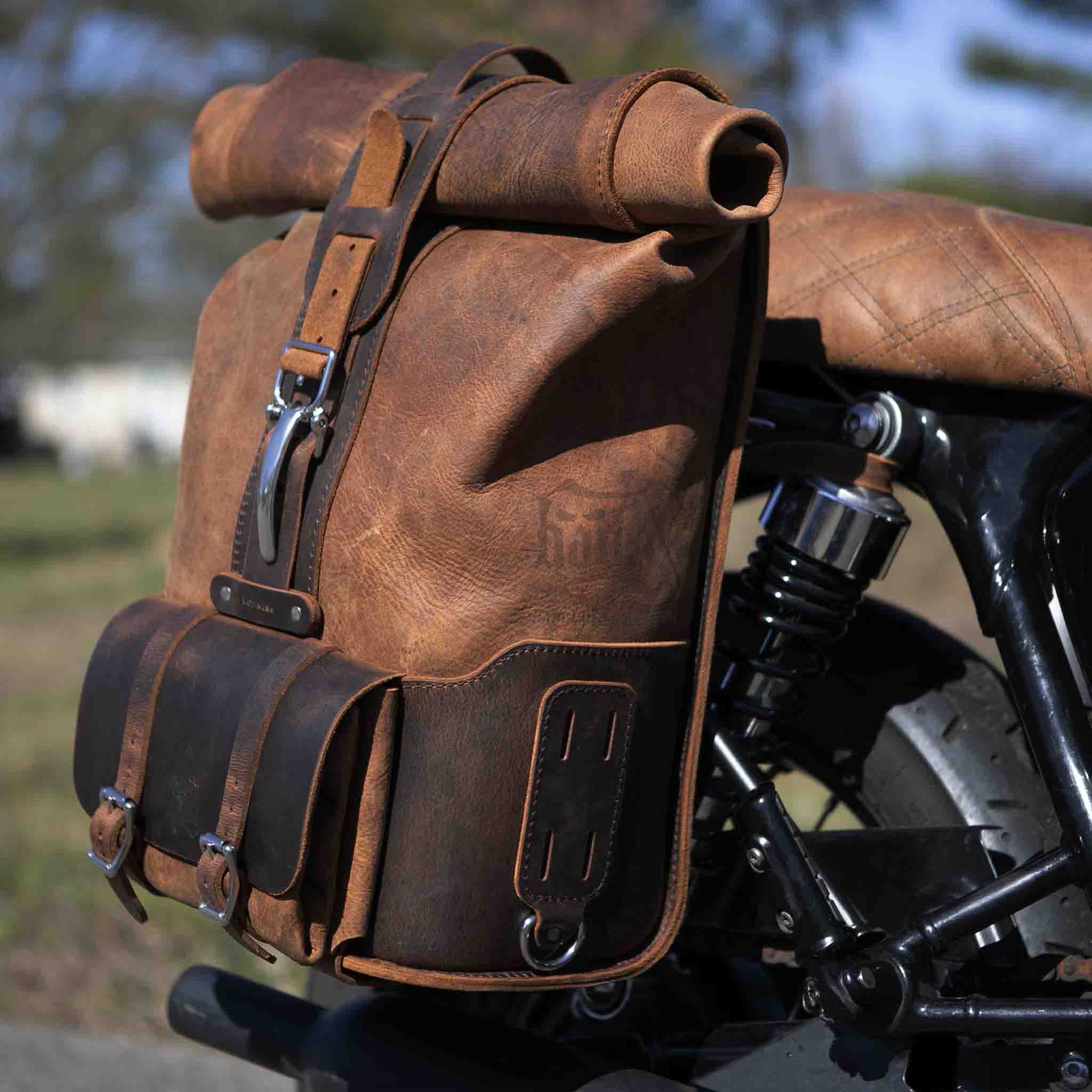 Upgrade your ride with the URB01 Rolltop Backpack Saddlebag. Unique design enables quick conversion from saddlebag to backpack. Hand crafted in USA with premium veg tan water buffalo leather and stainless steel hardware. Durable and stylish, it's the perfect fit for your motorcycle.